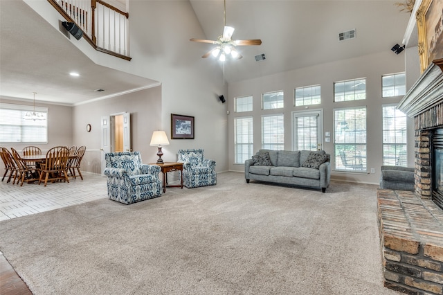 carpeted living room with ornamental molding, a high ceiling, a fireplace, and ceiling fan