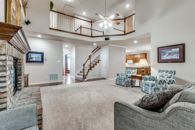 carpeted living room with a towering ceiling and ceiling fan