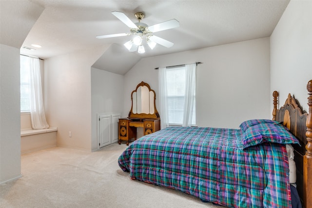 bedroom with a textured ceiling, multiple windows, light colored carpet, and ceiling fan