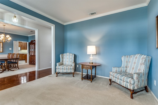 sitting room with a notable chandelier, ornamental molding, and hardwood / wood-style floors