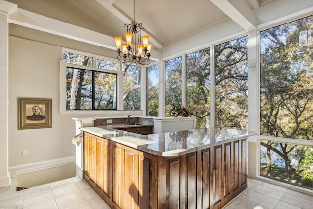 sunroom / solarium featuring lofted ceiling and a notable chandelier