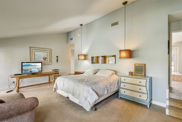 carpeted bedroom with high vaulted ceiling