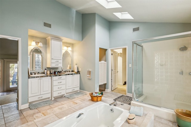 bathroom with independent shower and bath, vanity, high vaulted ceiling, and a skylight