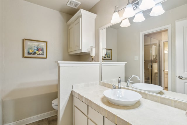 bathroom with tile patterned floors, vanity, toilet, and an enclosed shower