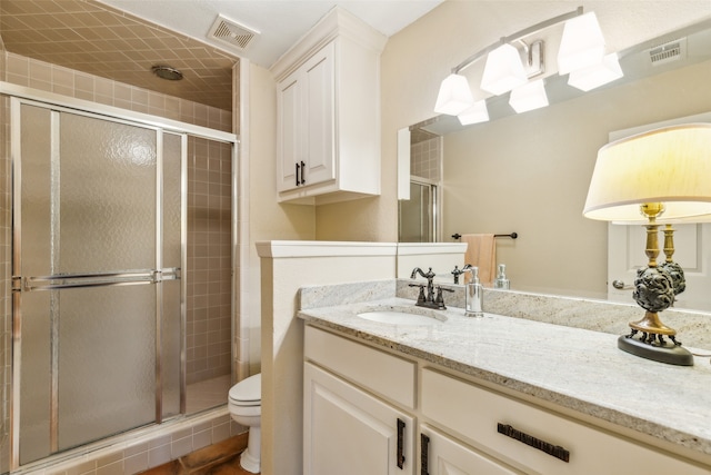 bathroom with vanity, toilet, and a shower with shower door