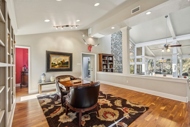 living area featuring ceiling fan with notable chandelier, light hardwood / wood-style flooring, lofted ceiling with beams, and ornate columns