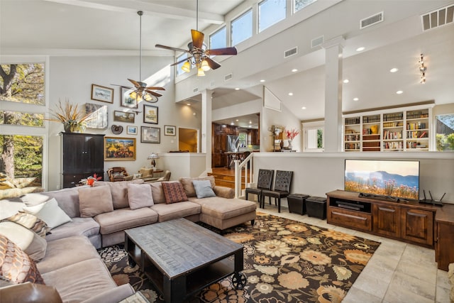 living room featuring light tile patterned floors, a towering ceiling, decorative columns, and beamed ceiling