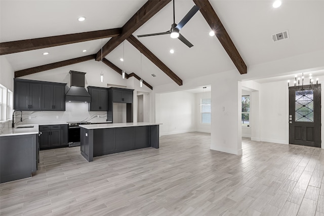 kitchen with a center island, stainless steel range with electric cooktop, light wood-type flooring, tasteful backsplash, and custom range hood