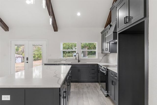 kitchen with a center island, sink, light hardwood / wood-style flooring, beamed ceiling, and stainless steel range with electric cooktop