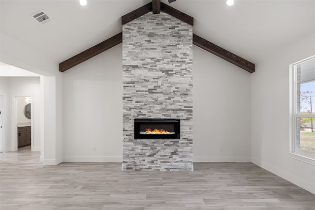 unfurnished living room with vaulted ceiling with beams, light hardwood / wood-style flooring, and a tile fireplace