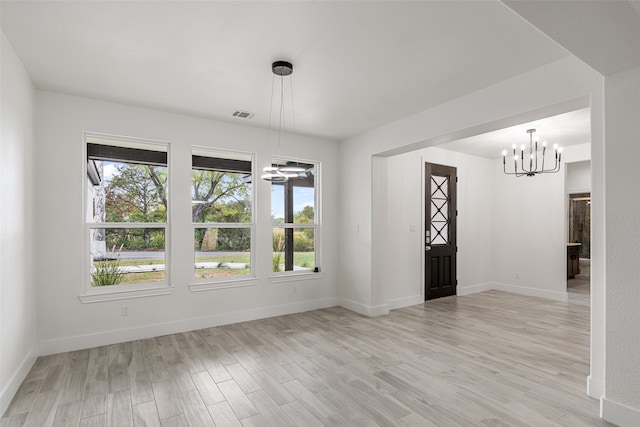 entrance foyer featuring plenty of natural light, a chandelier, and light hardwood / wood-style flooring