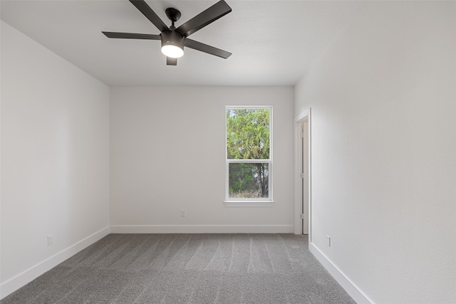 unfurnished room with ceiling fan and carpet