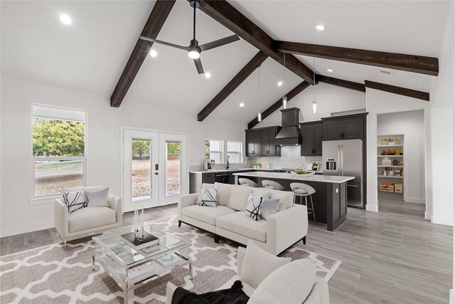 living room with ceiling fan, french doors, beamed ceiling, high vaulted ceiling, and light wood-type flooring