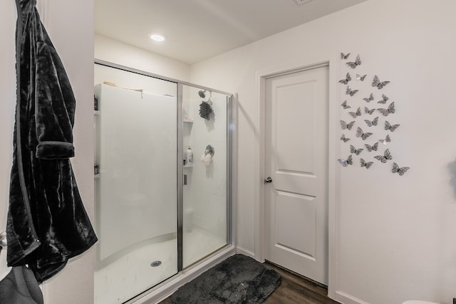 bathroom featuring a shower with door and hardwood / wood-style floors