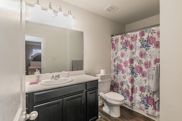 bathroom with toilet, hardwood / wood-style flooring, vanity, and a shower with curtain