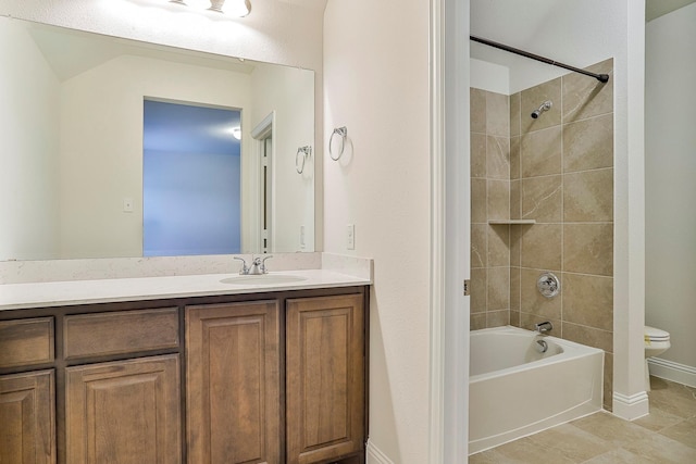 full bathroom featuring toilet, tiled shower / bath, vanity, and tile patterned flooring