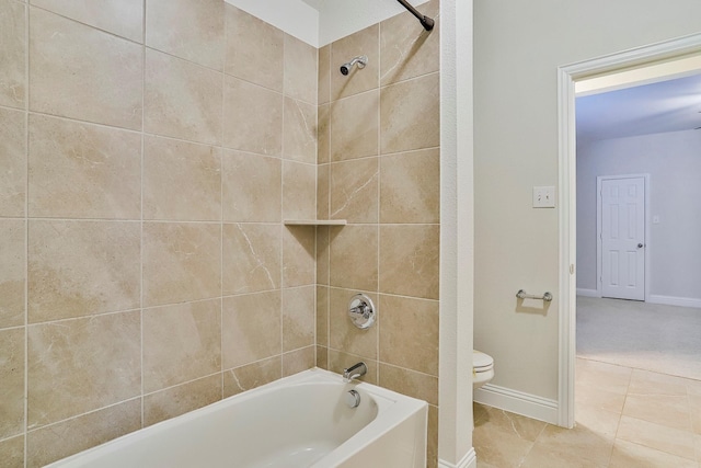 bathroom with tiled shower / bath combo, toilet, and tile patterned flooring