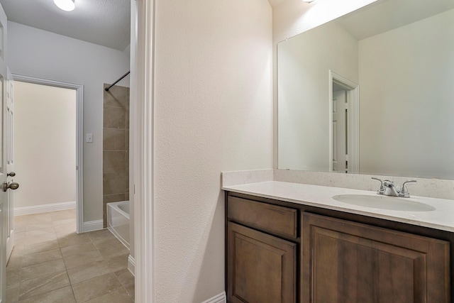 bathroom featuring tiled shower / bath, vanity, a textured ceiling, and tile patterned flooring