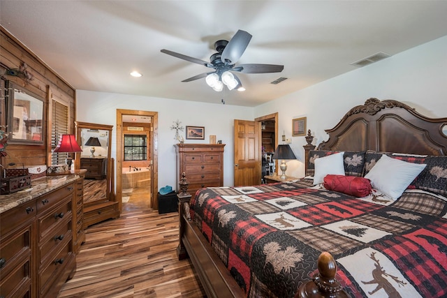 bedroom featuring ceiling fan, ensuite bath, and wood-type flooring