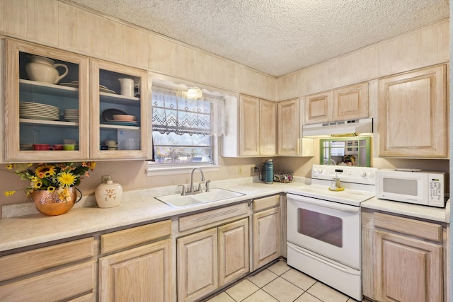 kitchen with light brown cabinets, sink, light tile patterned floors, a textured ceiling, and white appliances