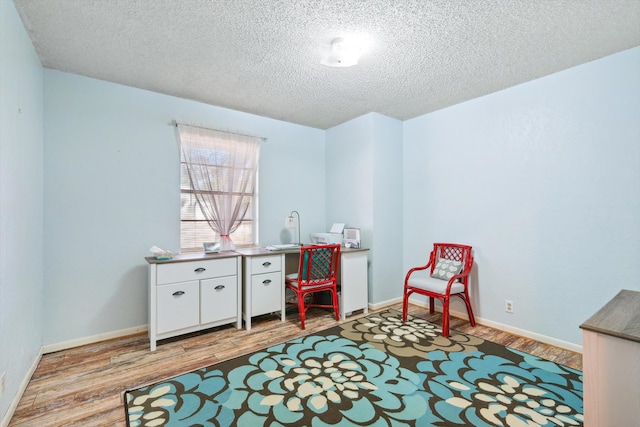 recreation room featuring a textured ceiling and light wood-type flooring