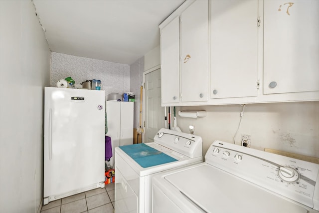 laundry room featuring washer and dryer, cabinets, and light tile patterned floors