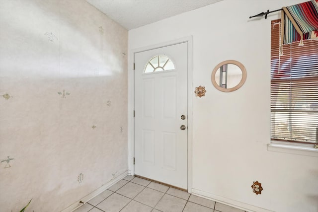 tiled entrance foyer with a textured ceiling and plenty of natural light