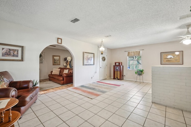 tiled entryway featuring ceiling fan and a textured ceiling