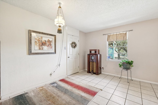 foyer with a textured ceiling and light tile patterned floors