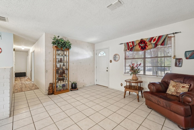 tiled living room featuring a textured ceiling