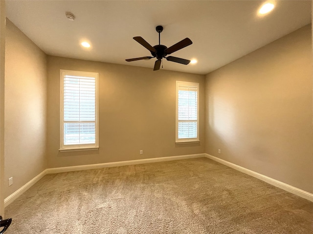 carpeted spare room featuring ceiling fan