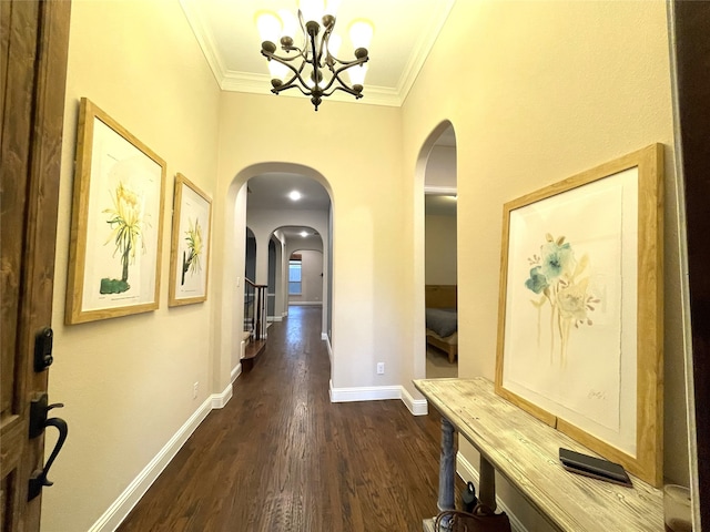 hall with ornamental molding, a chandelier, and dark hardwood / wood-style flooring