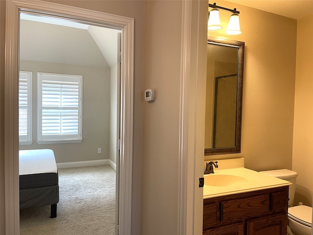 bathroom featuring toilet, walk in shower, and vanity