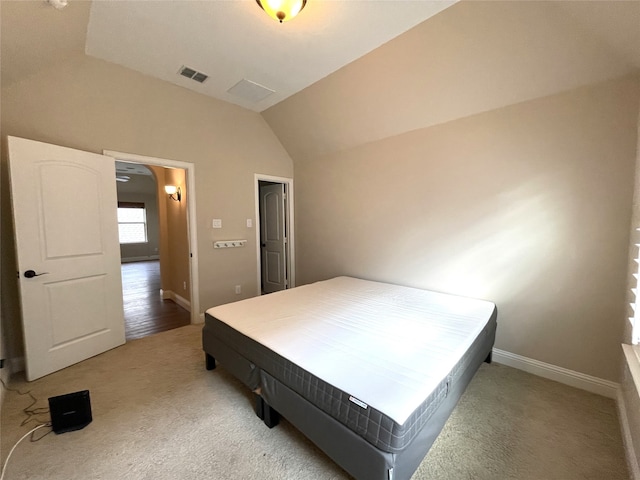 bedroom featuring vaulted ceiling and light colored carpet