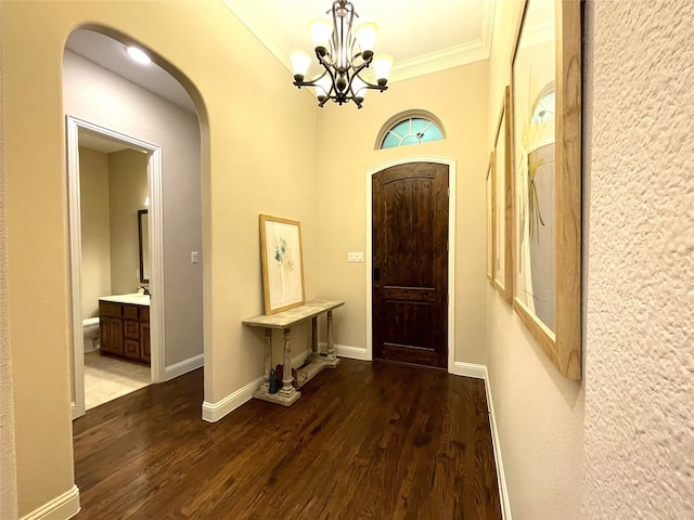 foyer entrance with ornamental molding, hardwood / wood-style floors, a chandelier, and sink