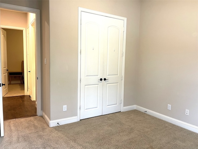 unfurnished bedroom featuring light carpet and a closet