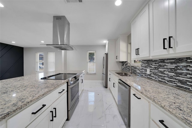 kitchen with wall chimney range hood, a healthy amount of sunlight, sink, and appliances with stainless steel finishes