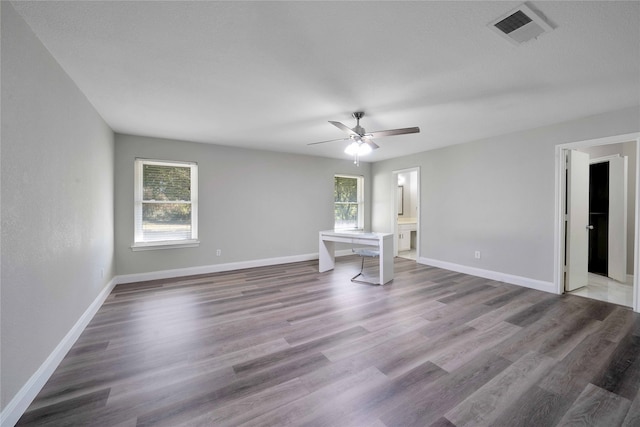 spare room with ceiling fan, a wealth of natural light, and hardwood / wood-style floors