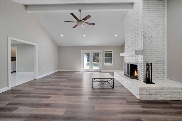 unfurnished living room featuring dark hardwood / wood-style floors, beam ceiling, a fireplace, high vaulted ceiling, and ceiling fan