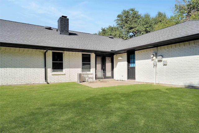 rear view of house with a patio and a lawn