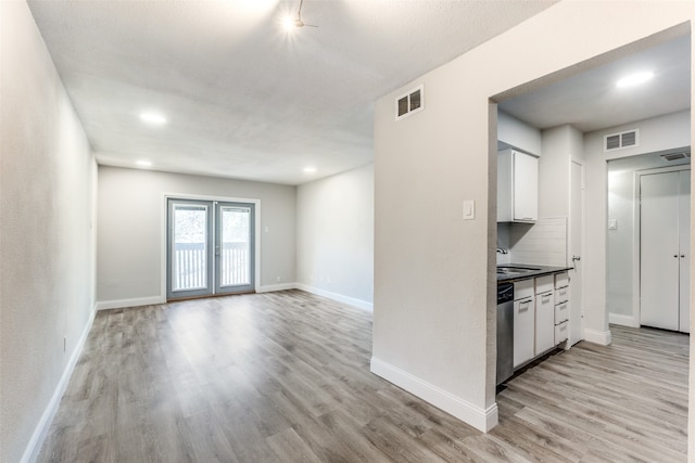 kitchen featuring white cabinetry, light hardwood / wood-style flooring, and backsplash