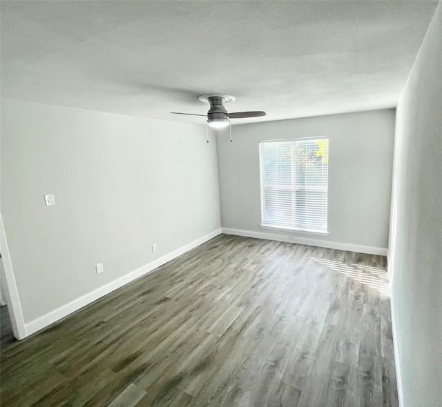 spare room with a textured ceiling, dark wood-type flooring, and ceiling fan