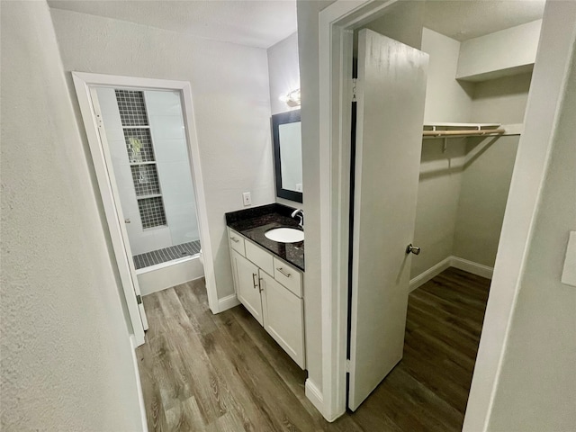 bathroom with vanity, wood-type flooring, and walk in shower