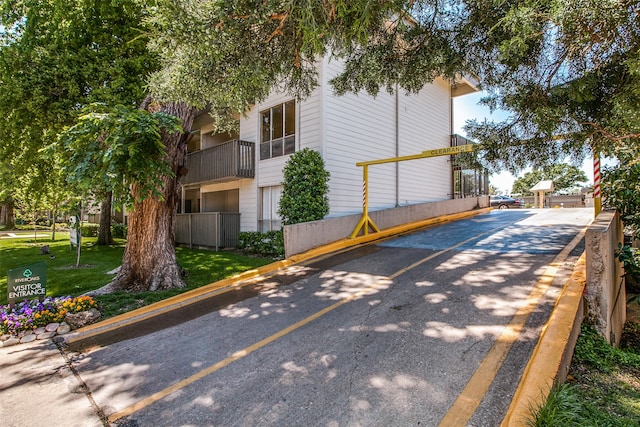 view of side of home featuring a lawn and a balcony