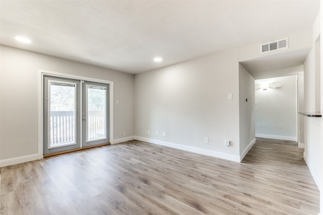 empty room with french doors and light hardwood / wood-style floors