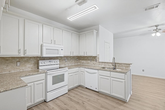 kitchen with sink, white cabinets, light wood-type flooring, and white appliances