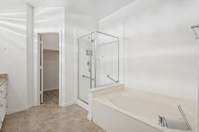 bathroom with vanity, tile patterned flooring, and plus walk in shower