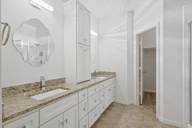 bathroom featuring vanity, a shower with shower door, and tile patterned flooring