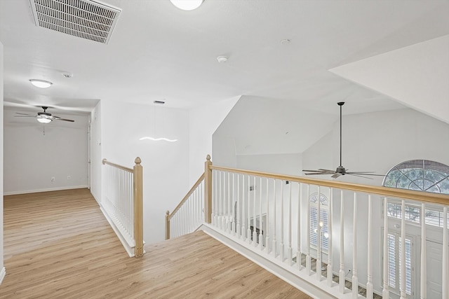 hall featuring lofted ceiling and light wood-type flooring