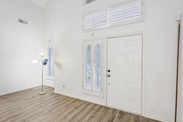 foyer with a high ceiling and light wood-type flooring